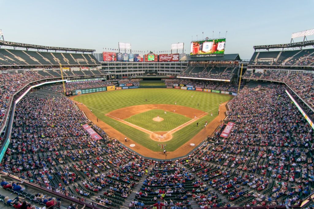 Aerial view of a lively baseball game at the iconic Globe Life Park filled with cheering fans.